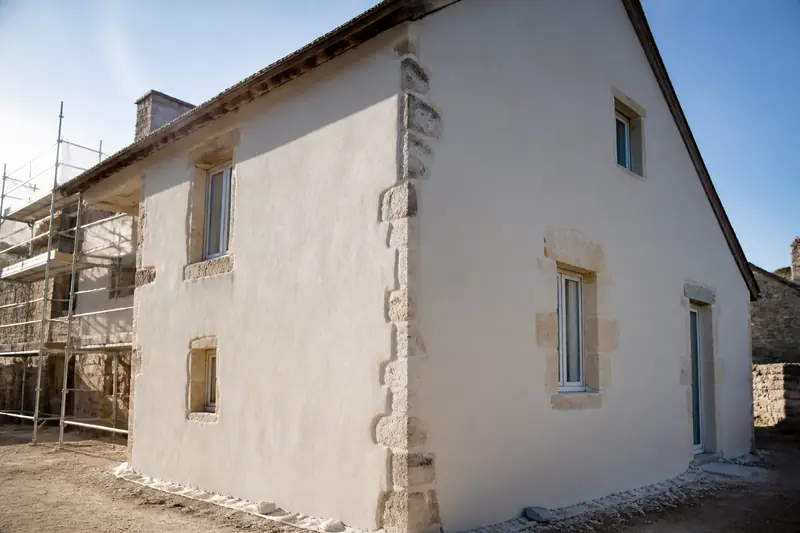 Mur en pierre apparente en cours de recouvrement par un isolant fibre de bois