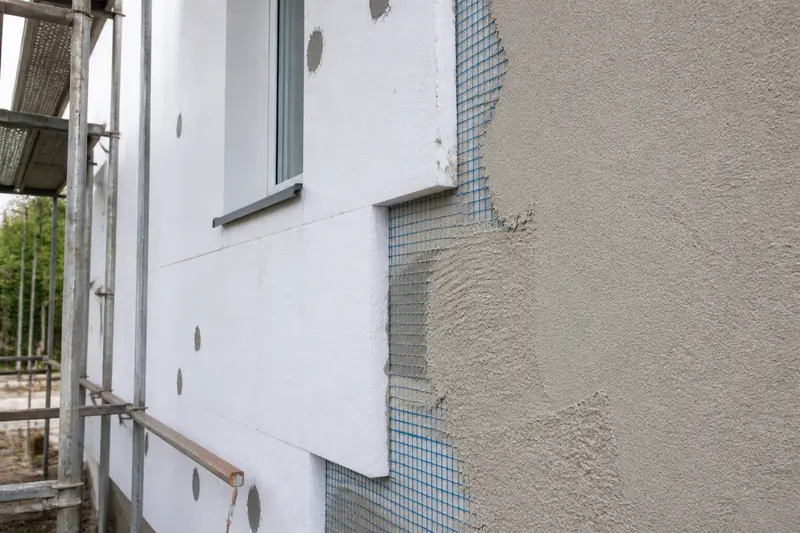 Façade de maison en cours d'isolation par l'extérieur sous enduit